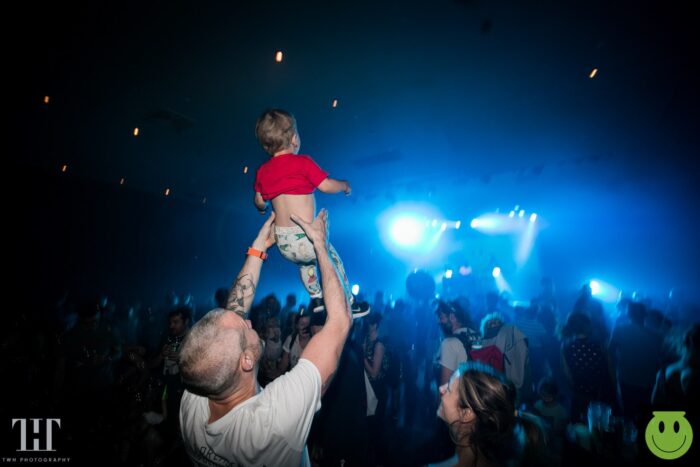 dad holding baby up at rave